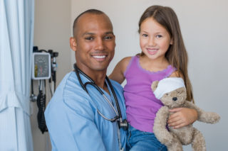FQHC nurse practitioner holding small girl